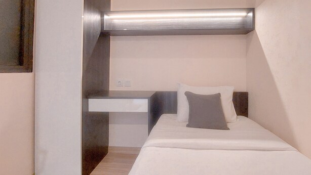A modern hotel room with a bed, bedside table, and a large window. - Best Place And Wonderful 3Br Apartment Sky House Bsd Near Aeon Mall (Pagedangan)