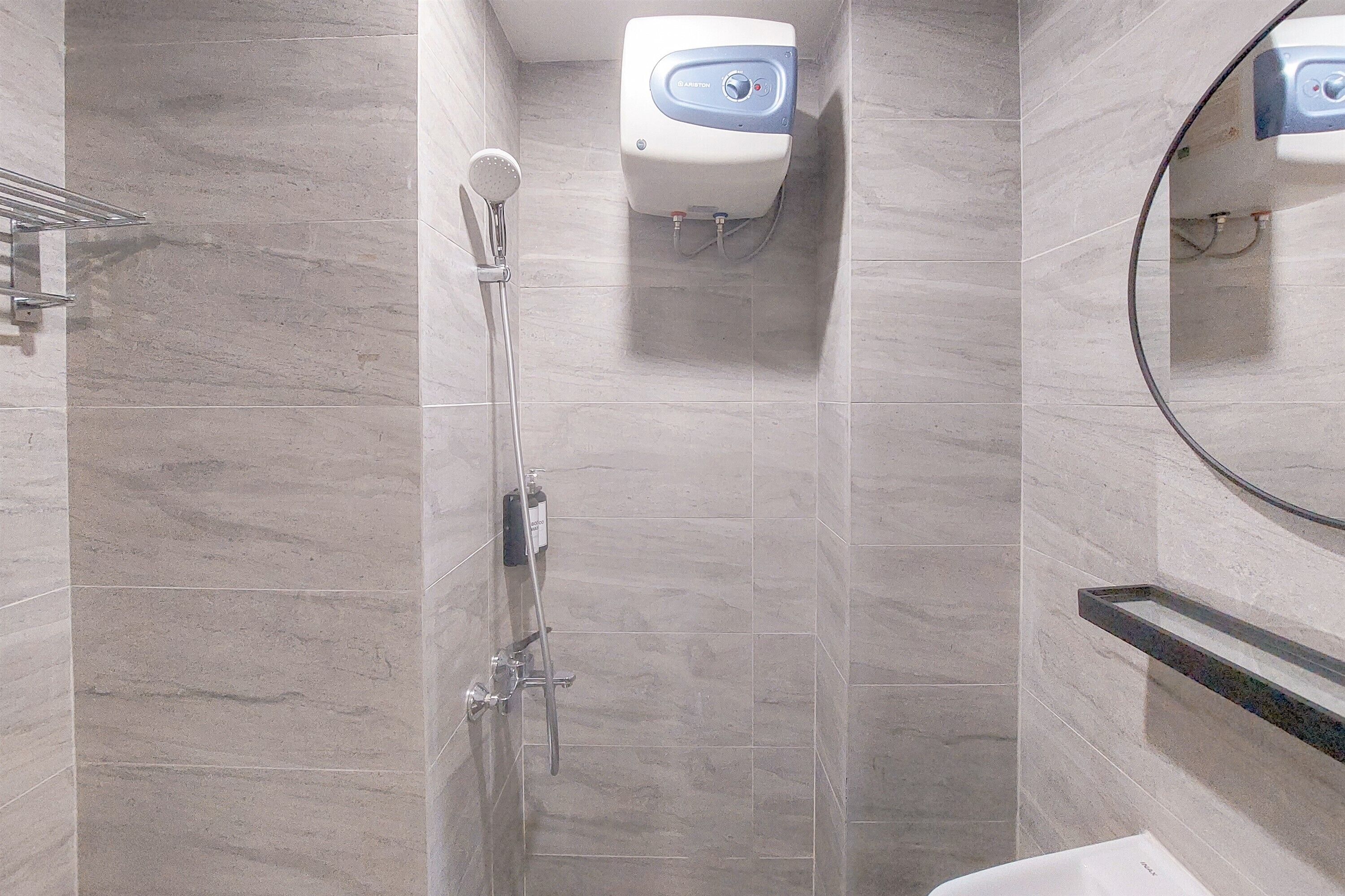 A modern bathroom with a shower, a toilet, and a mirror.