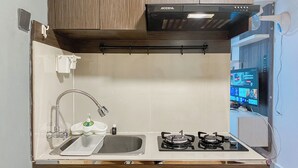 Moderni keittiö, jossa on kaasuliesi, pesuallas ja sisäänrakennettu uuni.