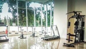 A gym with various exercise equipment, large windows, and a tiled floor. - Good Deal And Scenic 1Br Apartment At Woodland Park Residence (Jakarta)