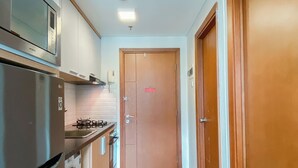 A modern kitchen with stainless steel appliances, a microwave, and a gas stove. - Good Deal And Scenic 1Br Apartment At Woodland Park Residence (Jakarta)