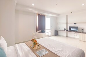 Een hotelkamer met een bed, een bureau, een stoel en een televisie.