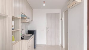 Una cucina moderna con mobili in legno chiaro, lavastoviglie integrata e lavello in acciaio inox.
