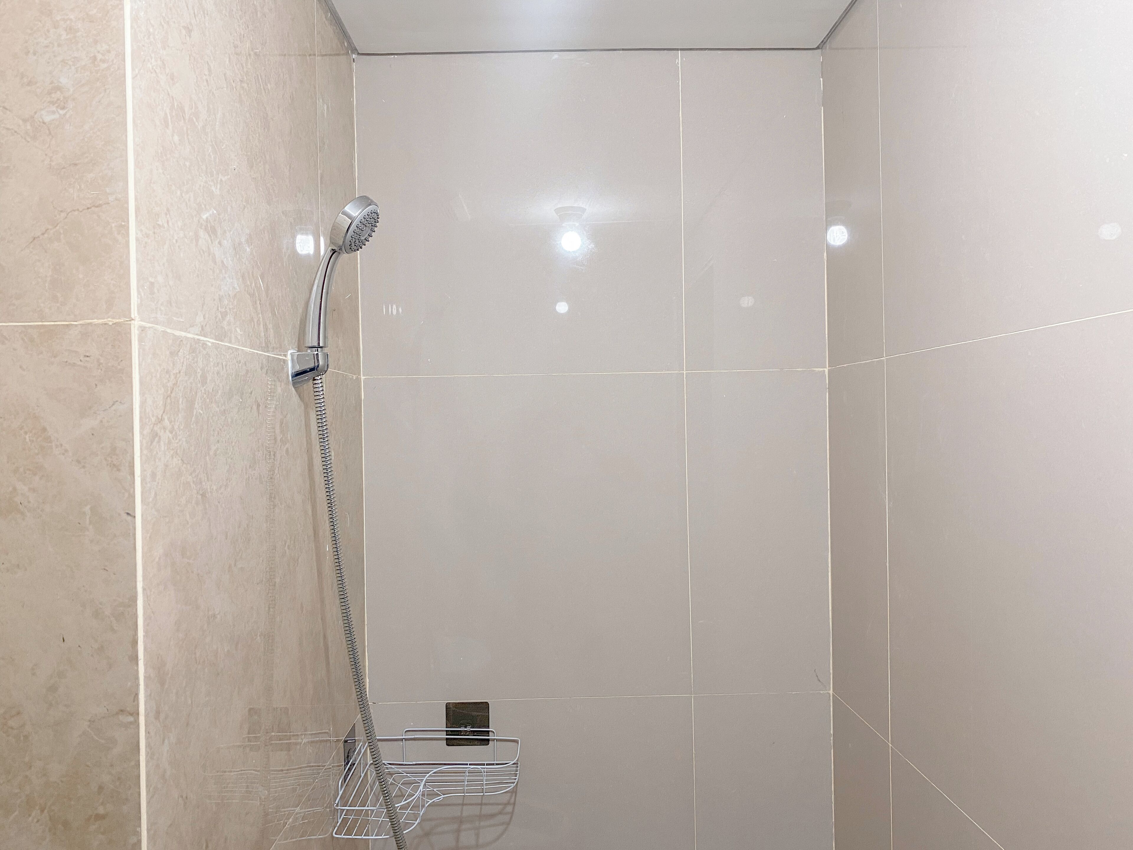 A modern bathroom with a shower, tiled walls, and a metal shower tray.