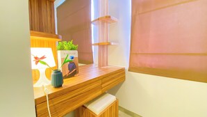 A wooden vanity with a mirror, a vase with flowers, and a book titled 'KINFOLK'. - Spacious And Elegant 1Br At Apartment Silkwood Residence (Tangerang)