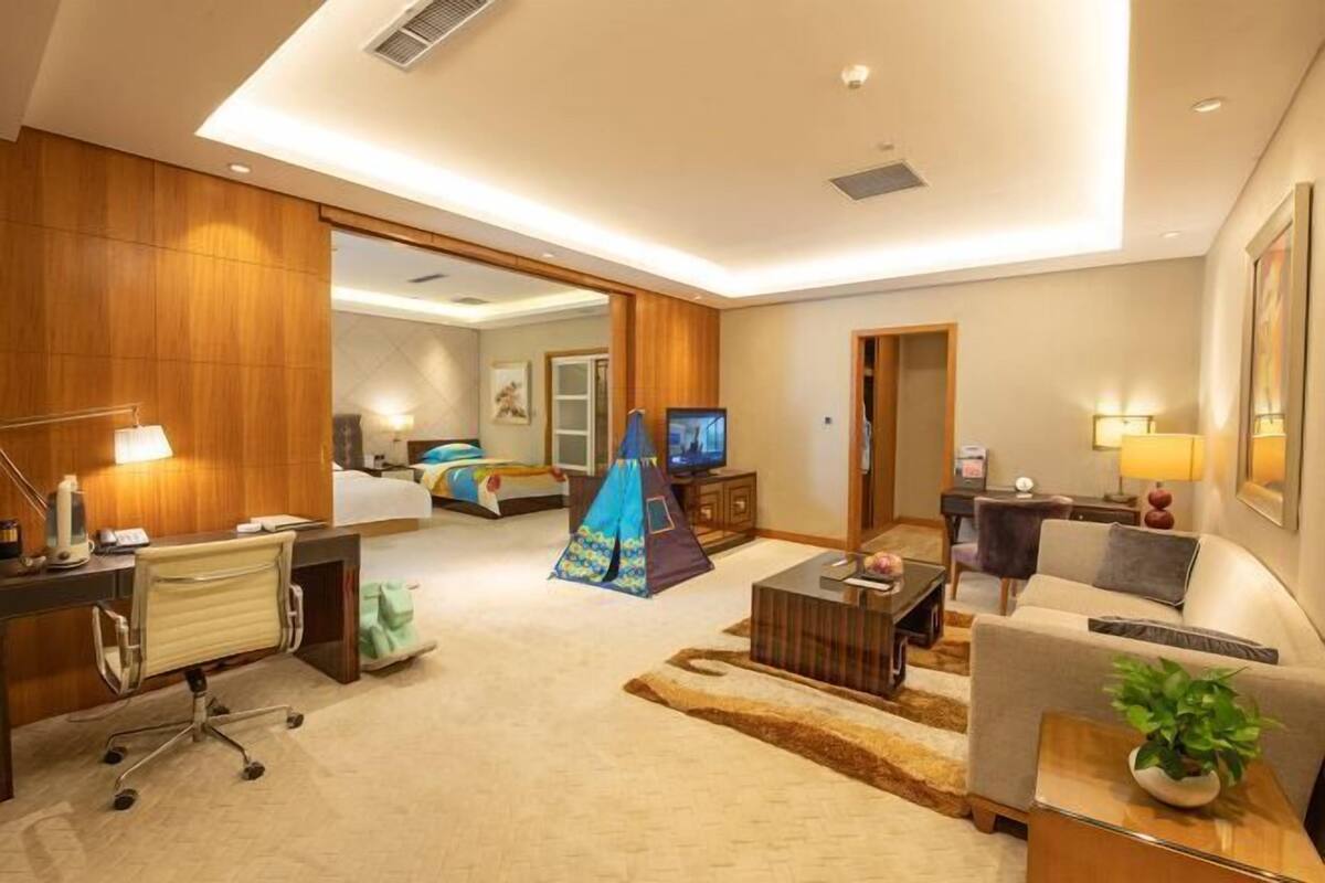 Ein Hotelzimmer mit Schreibtisch, Stuhl, Bett, Fernseher und einem Zelt.