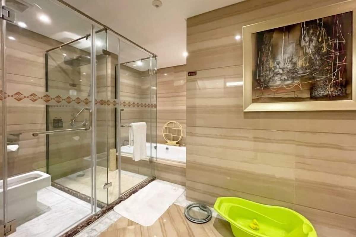 Ein modernes Badezimmer mit einer Duschkabine, einer Badewanne und einem grünen Waschbecken.