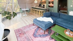 Une tente spacieuse comprenant un coin repas, une cuisine et un espace détente.