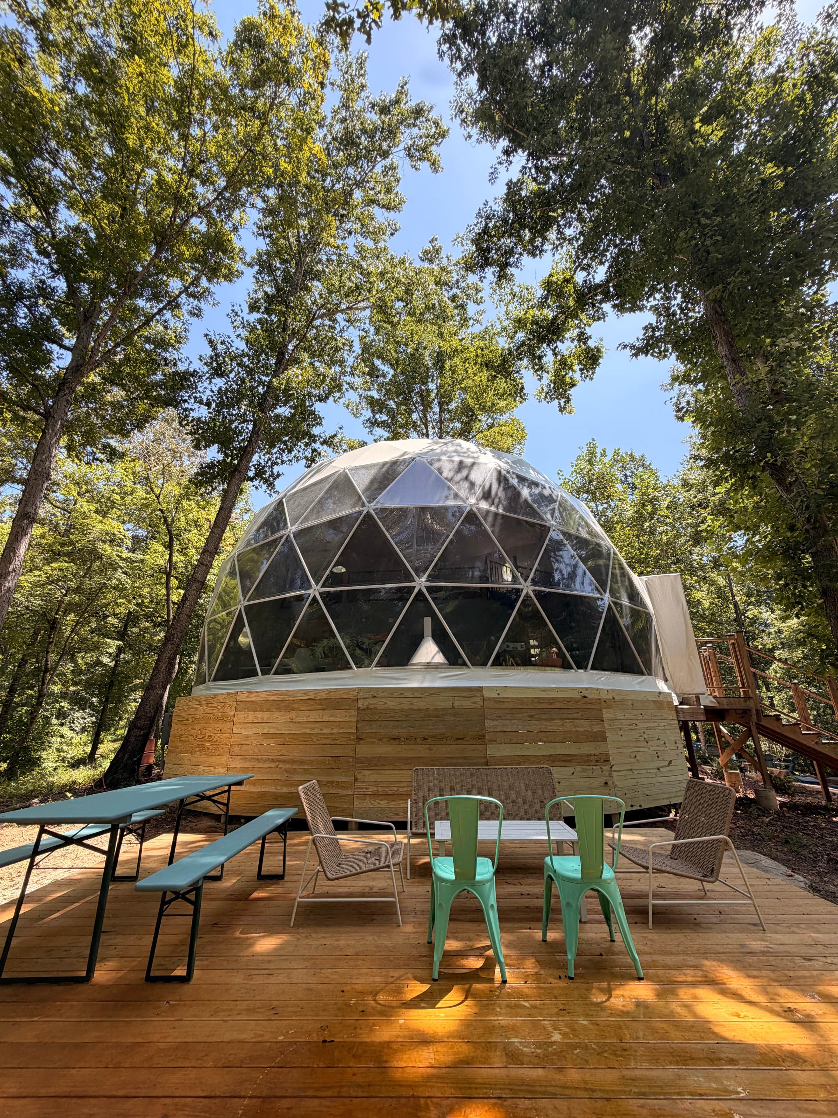 A dome-shaped structure with a wooden deck and seating area.