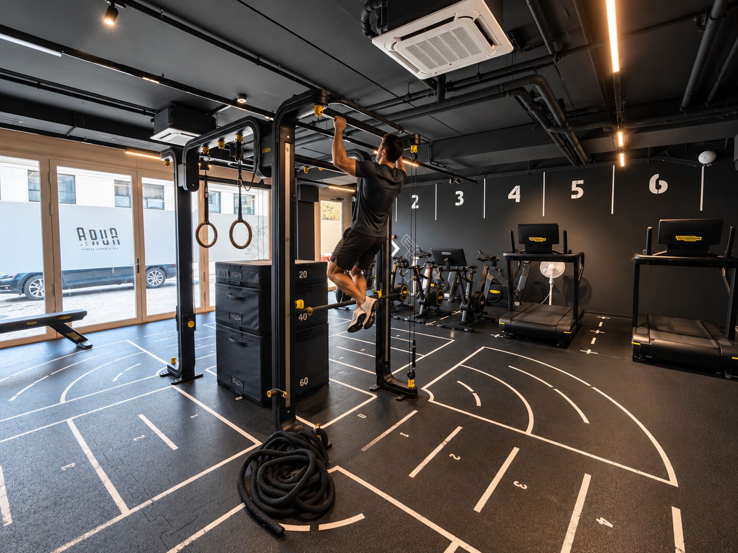 Une salle de sport équipée d’une barre de traction, de supports pour les poids et d’appareils d’exercice.