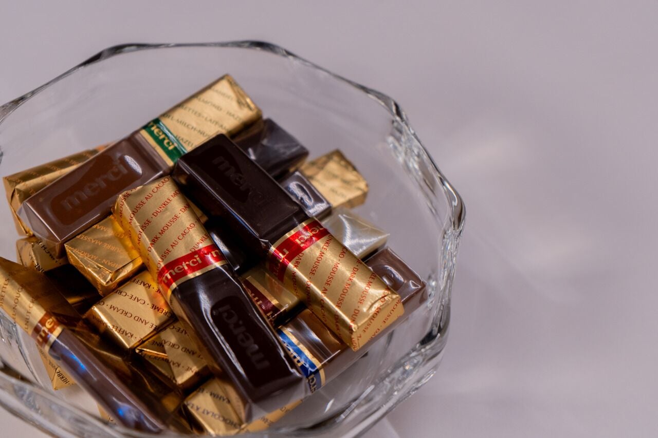 Una ciotola di vetro con cioccolatini assortiti.