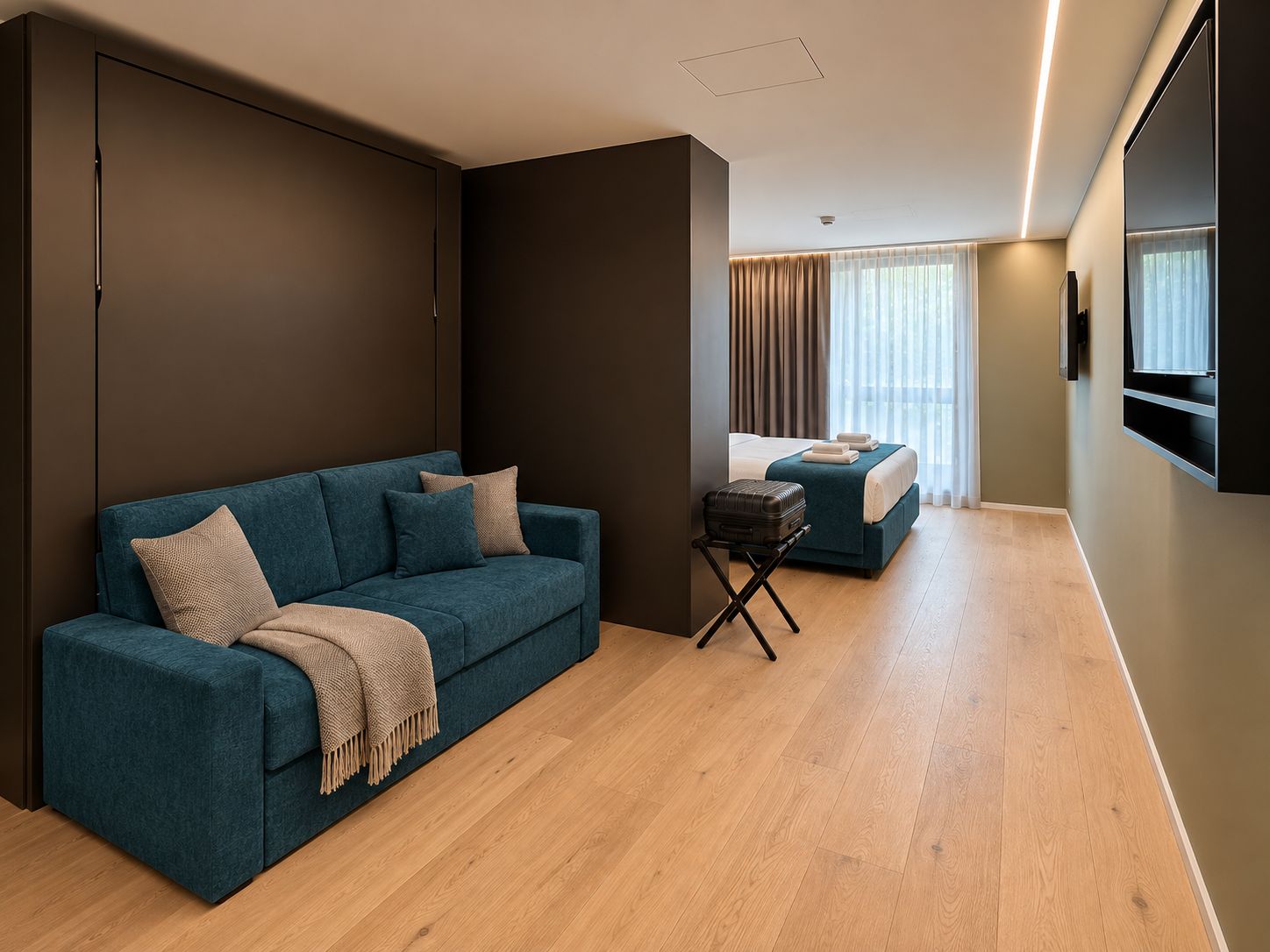 Una habitación de hotel moderna con un sofá, una cama, una mesita y una maleta.