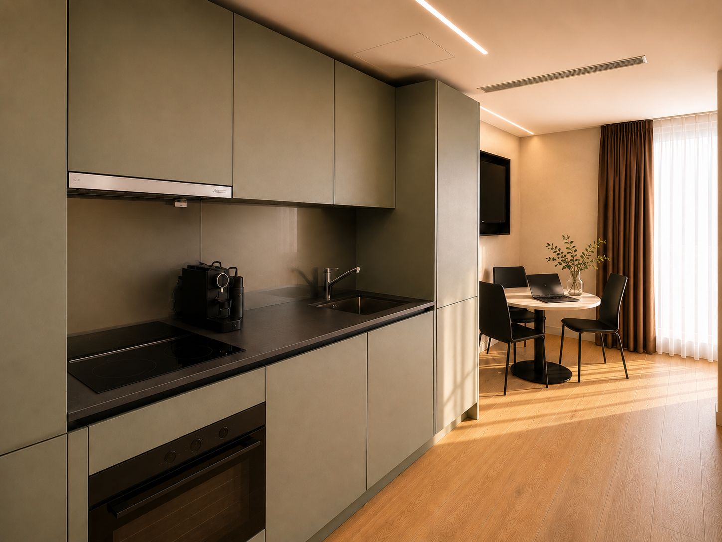 A modern kitchen with built-in appliances, a dining area with a table and chairs, and a flat-screen TV mounted on the wall.