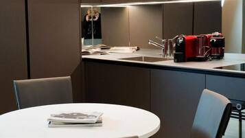 Eine moderne Küche mit eingebautem Spülbecken, einer roten Kaffeemaschine und einem Spiegel über der Arbeitsplatte.