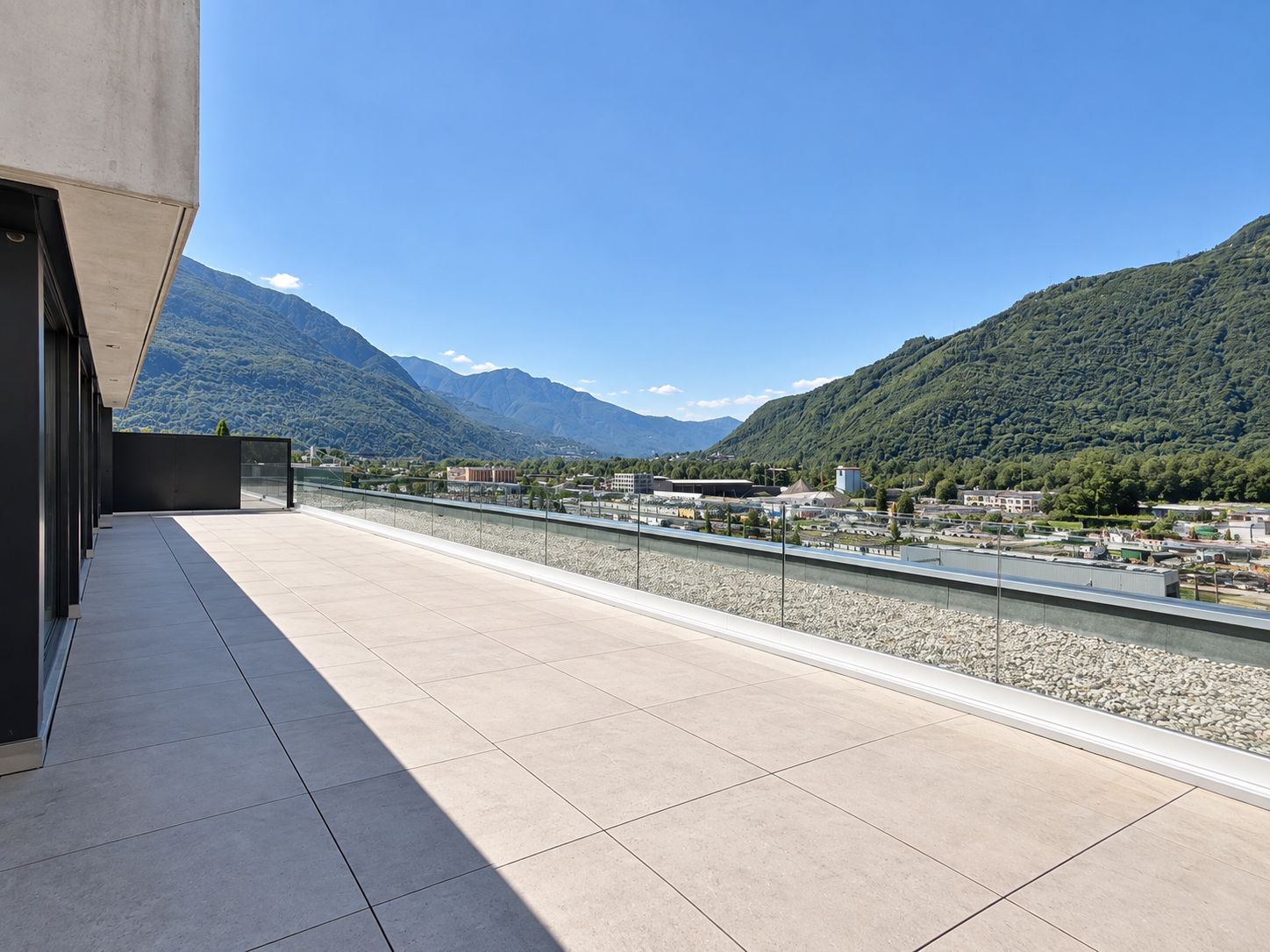 Una terraza en la azotea con vistas a un río y montañas.