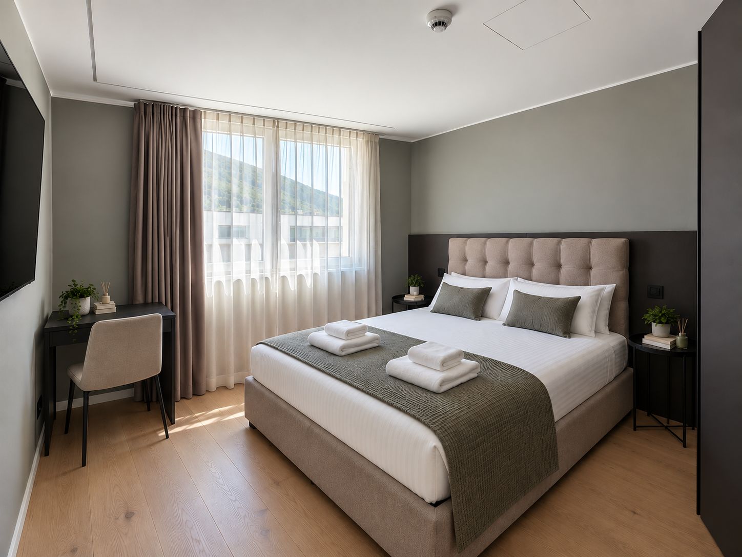 Une chambre d’hôtel moderne avec un grand lit, un bureau et une chaise.