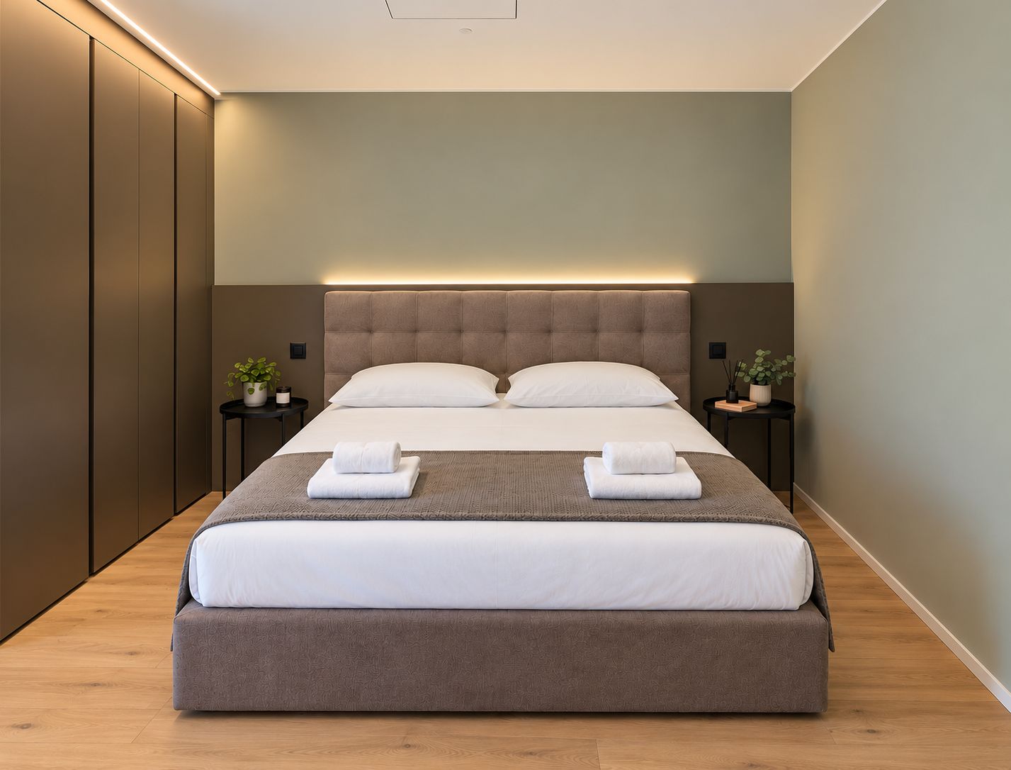 Une chambre à coucher moderne avec un grand lit, deux tables de chevet et une armoire intégrée.