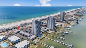 Un hôtel situé sur la côte, avec de grands immeubles, une plage et un port de plaisance.