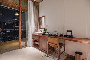 A modern bathroom with a large window, a wooden vanity, a mirror, and a view of the city at night. - 22land Residence Suite (Hanoi)