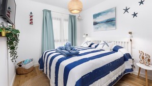 Une chambre avec un lit, une télévision, une plante et un mur décoré d’étoiles.