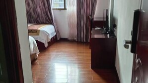 A room with a bed, a desk, and a television. - Yinjiang Lihao Hotel (Yinjiang)