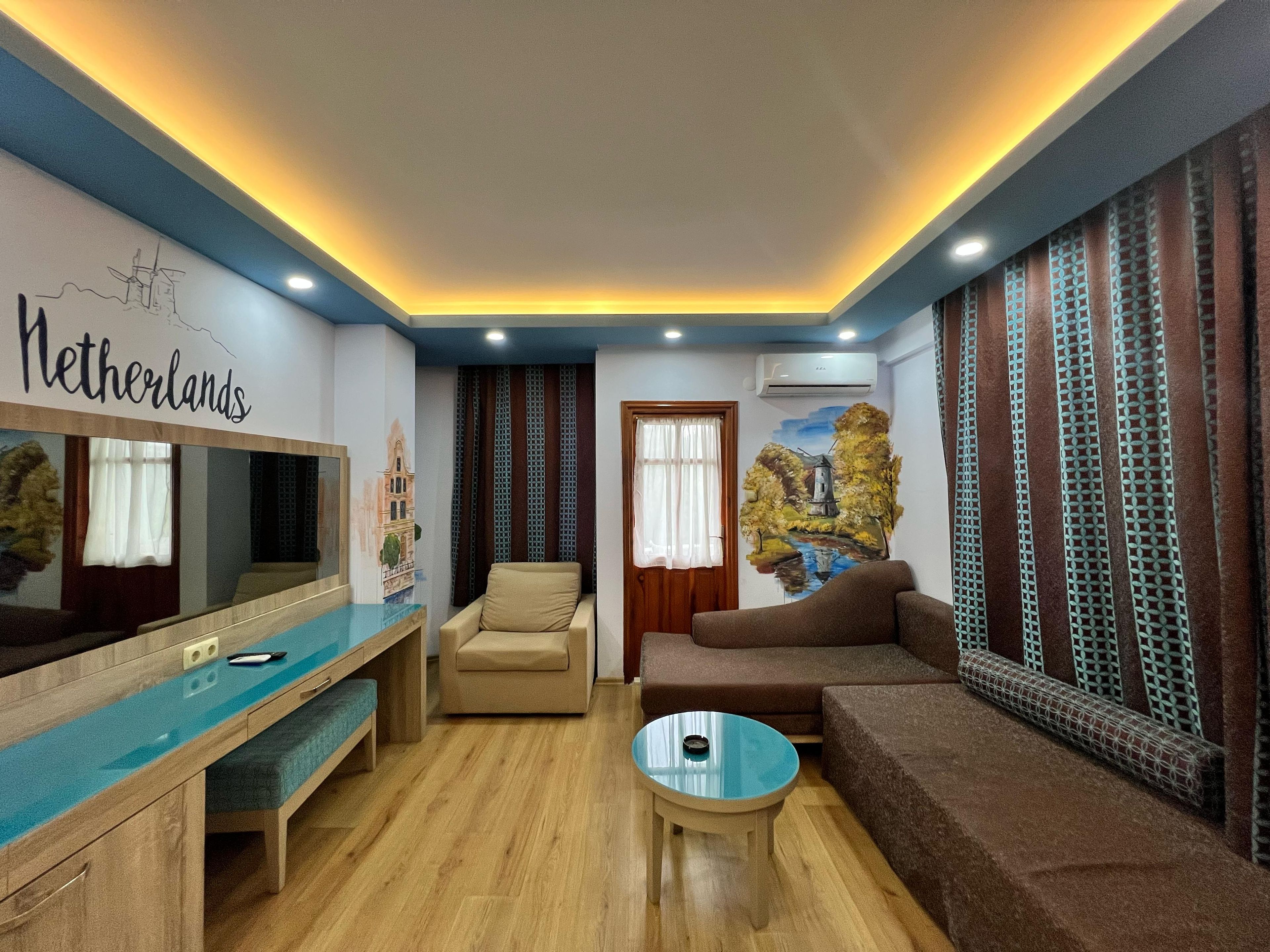 A living room with a wooden floor, a sofa, a chair, a coffee table, and a TV.