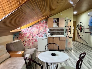 Une cuisine de taille réduite, avec des meubles de rangement en bois, un réfrigérateur blanc et un petit plan de travail.
