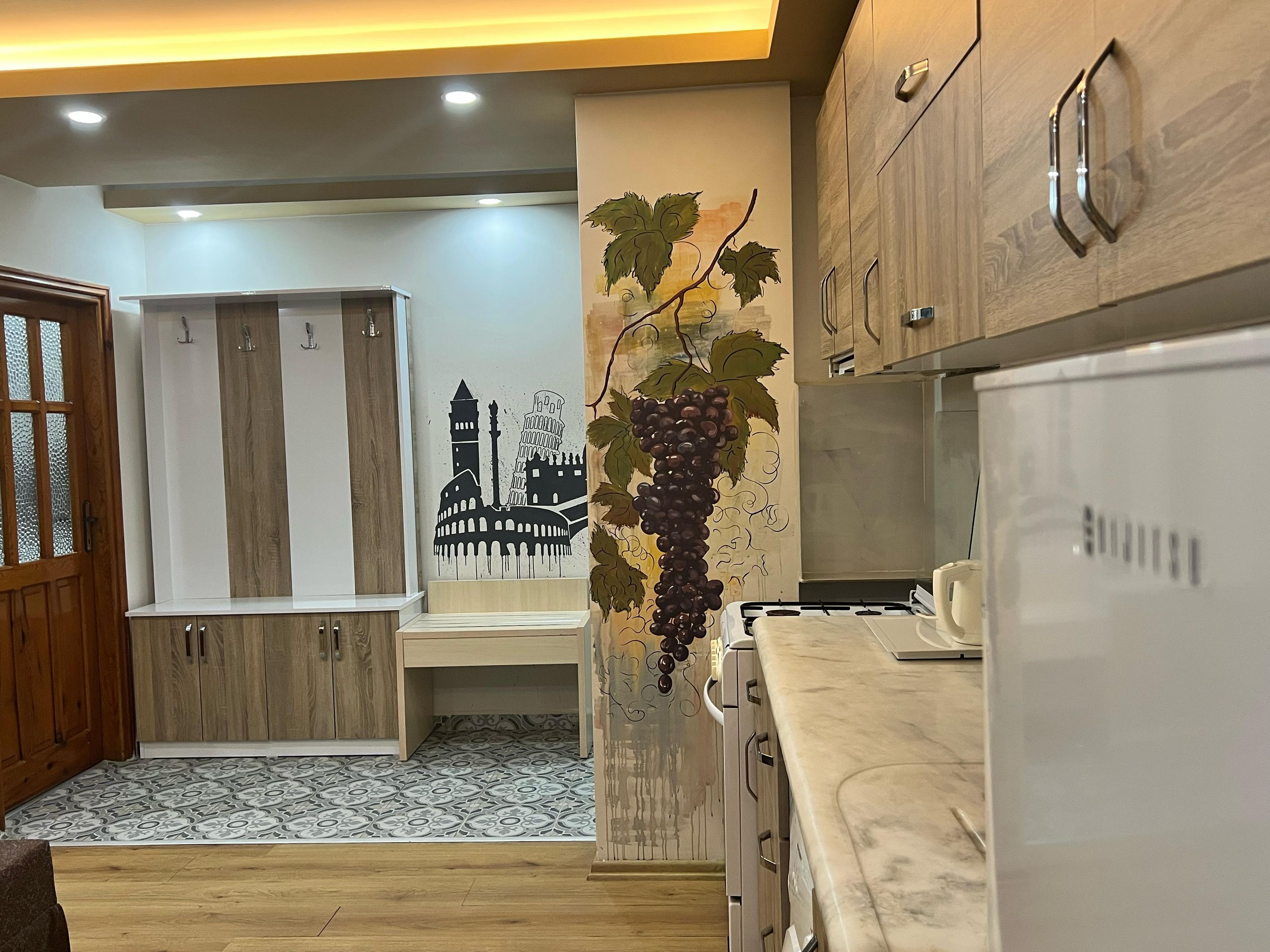 A modern kitchen with wooden cabinets, a marble countertop, and a wall-mounted sink.