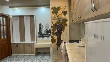 A modern kitchen with wooden cabinets, a marble countertop, and a wall-mounted sink.