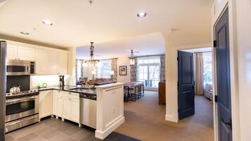 A modern kitchen with white cabinetry, stainless steel appliances, and a central island.