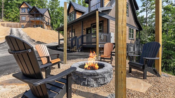 A cabin with a fire pit, outdoor seating, and a wooden deck.