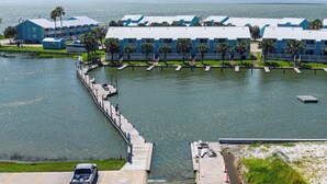A waterfront hotel with a dock, a parking area, and a view of the ocean. - Kontiki Beach Resort #317 by Miss Kitty’s (Rockport)