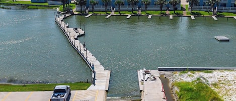 A waterfront hotel with a dock, a parking area, and a view of the ocean.