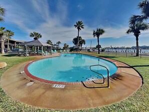 A circular pool with a 3 ft depth marker, surrounded by grass, palm trees, and a gazebo. - Pelican B'reef by Miss Kitty’s (Rockport)
