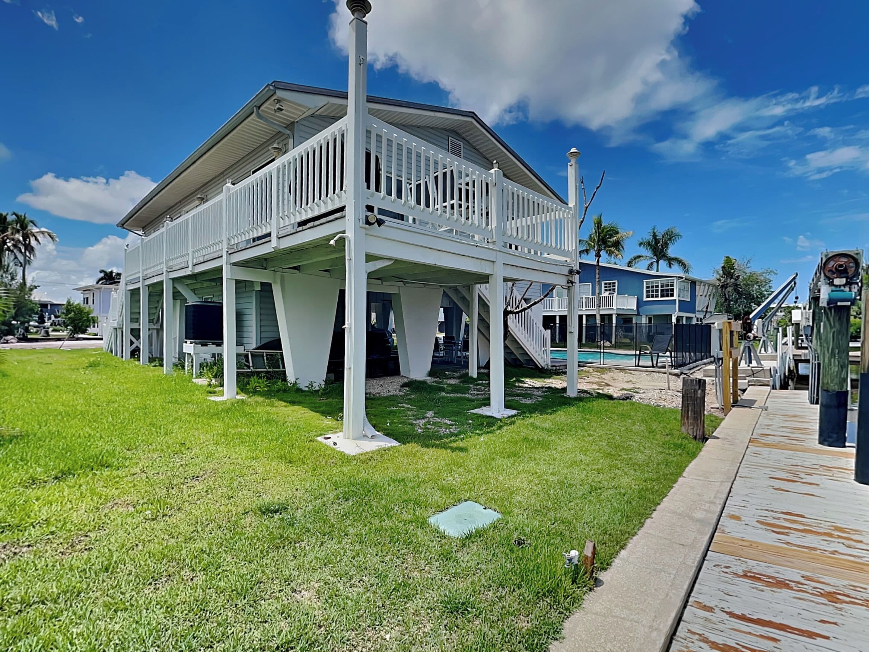 A two-story house with a balcony, a covered porch, and a swimming pool.