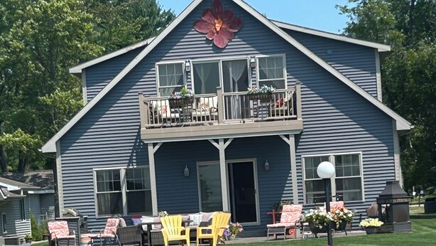 A two-story house with a balcony, a deck, and a small garden area.