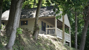 A house with a porch, surrounded by trees.