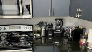 Una cocina moderna con electrodomésticos de acero inoxidable, encimera de granito y armarios grises.