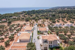 Ein Wohngebiet mit Häusern, einer Straße und Blick auf das Meer.