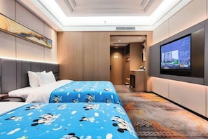 Ett hotellrum med två sängar, en tv och ett badrum som syns i bakgrunden.