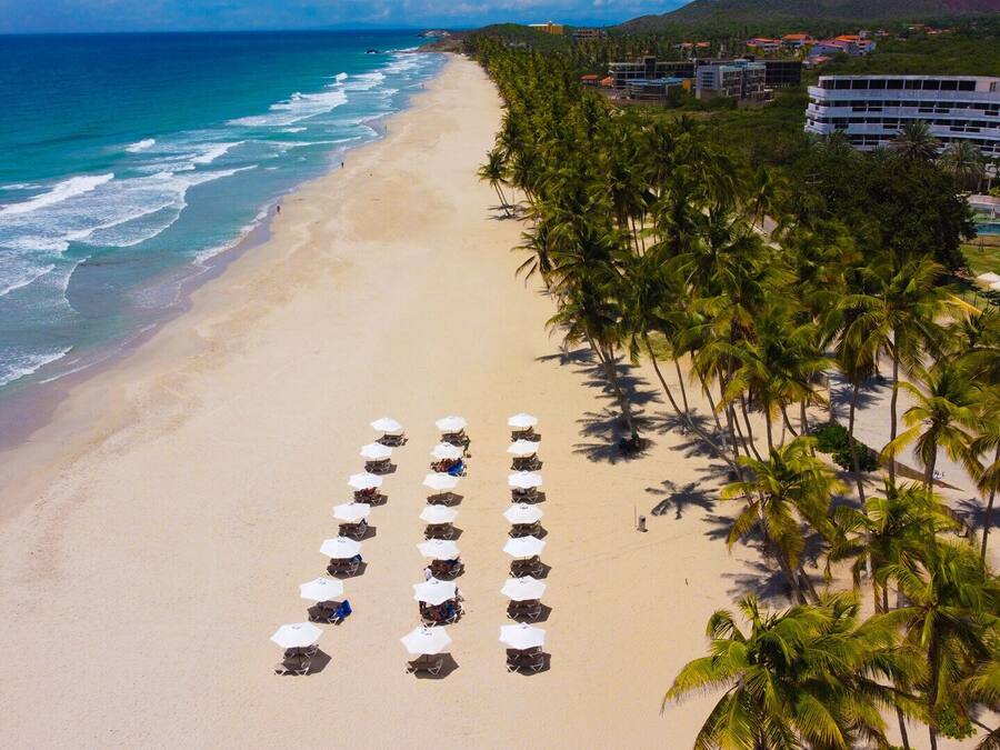 Am Strand, weißer Sandstrand, Liegestühle, Sonnenschirme