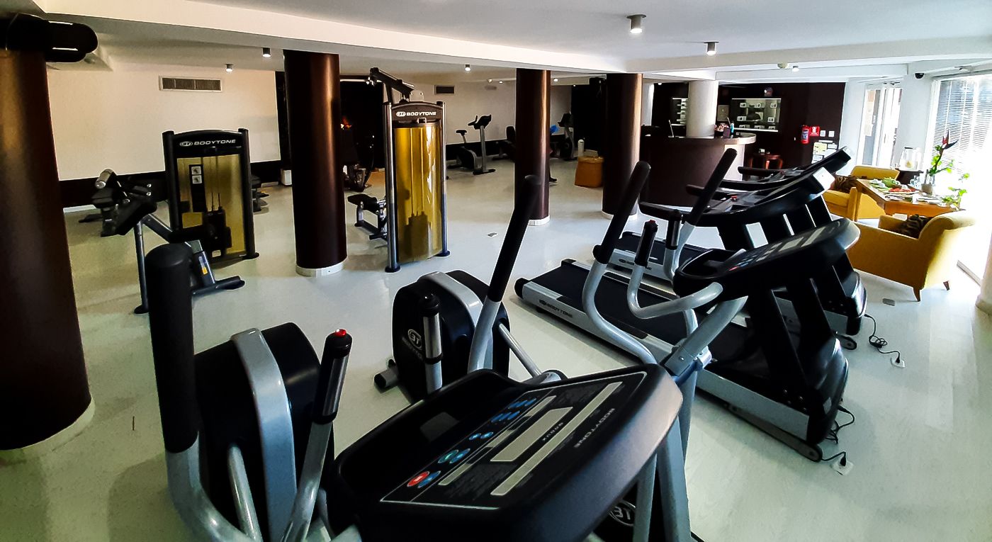 A gym with treadmills, weight machines, and a reception area.