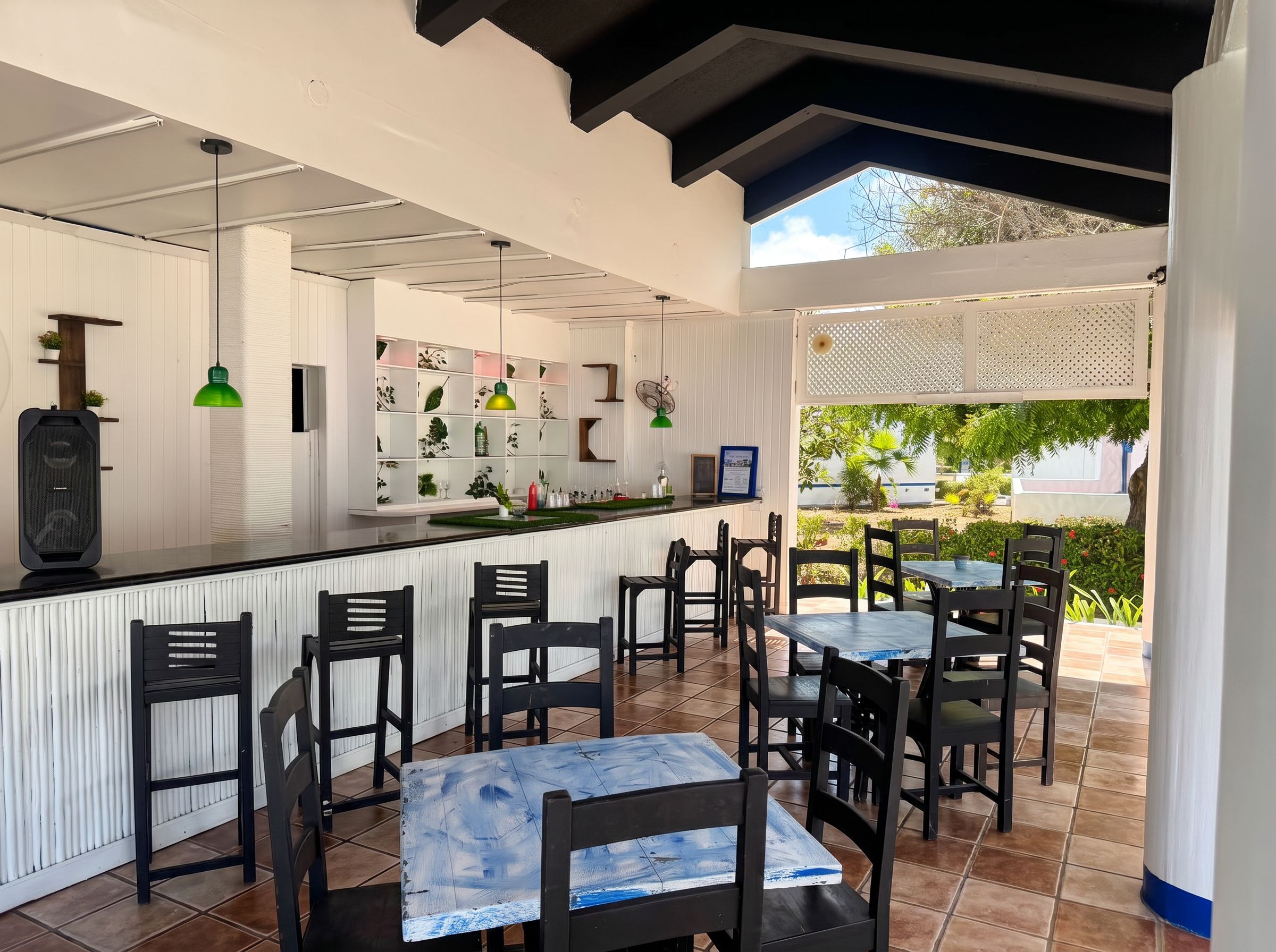 A restaurant with a bar area, outdoor seating, and a view of the garden.