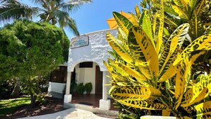 A hotel entrance with a sign reading "SUENOS ESTATAL HOSTAL" and a white building with a tiled roof. - Hostal Suenos Silvestres (Puerto Ayora)