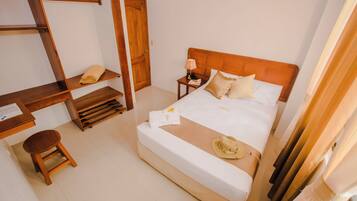 A hotel room with a wooden bed, a desk, and a chair.