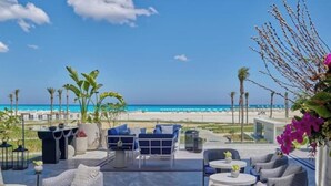 An outdoor seating area with a view of the beach and ocean.