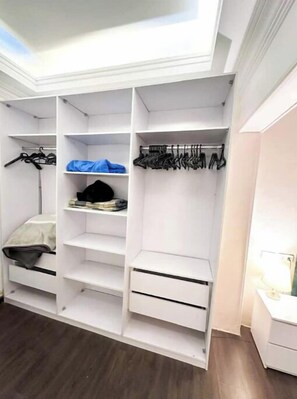 Organize your belongings in this spacious walk-in closet with ample shelving and drawers.