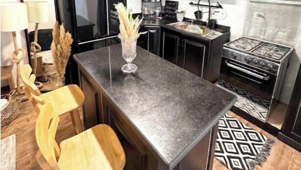 A modern kitchen with dark cabinetry, a central island, and a built-in oven. - cozy & 5 min. From Cairo airport

 (Cairo Governorate)
