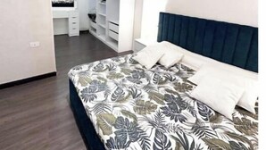 A bedroom with a bed, a wardrobe, and a desk. - cozy & 5 min. From Cairo airport

 (Cairo Governorate)