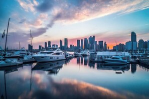A marina with boats and a city skyline in the background. - Tujia Sweetome Vacation Rentals (Middle Xianggang Road Lijing Yuzhu) (Qingdao)